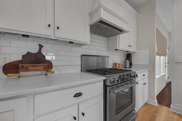 14980 Robins Rd, Johnstown, OH 43031 - kitchen featuring stainless steel gas stove, light wood finished floors, white cabinetry, decorative backsplash, and light countertops