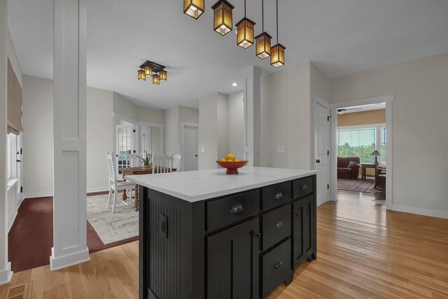 14980 Robins Rd, Johnstown, OH 43031 - kitchen with dark cabinetry, light wood-type flooring, baseboards, decorative light fixtures, and a center island