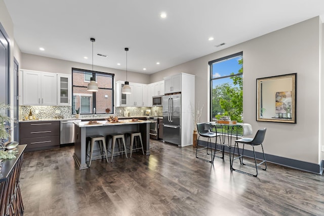123 Aston Row Ln, Columbus, OH 43201 - kitchen with appliances with stainless steel finishes, a kitchen breakfast bar, a kitchen island, tasteful backsplash, and white cabinets