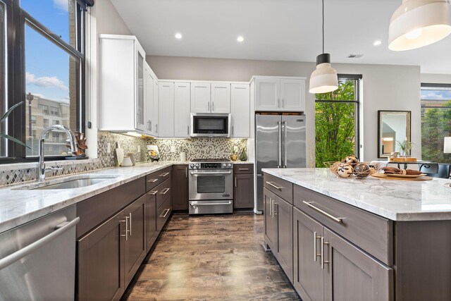 123 Aston Row Ln, Columbus, OH 43201 - kitchen featuring stainless steel appliances, a sink, dark wood-style floors, white cabinets, and backsplash