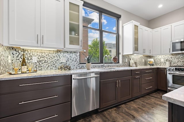 123 Aston Row Ln, Columbus, OH 43201 - kitchen with stainless steel appliances, a sink, white cabinets, dark brown cabinets, and light stone counters
