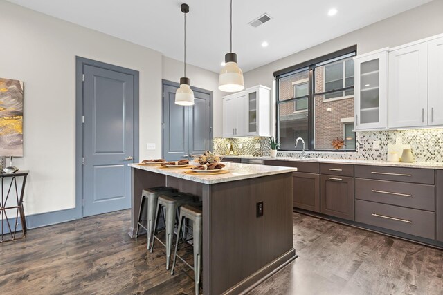 123 Aston Row Ln, Columbus, OH 43201 - kitchen with dark wood finished floors, glass insert cabinets, a center island, white cabinetry, and recessed lighting