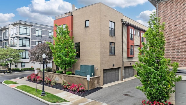 123 Aston Row Ln, Columbus, OH 43201 - view of building exterior with a garage and asphalt driveway