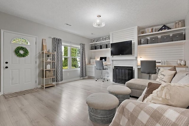 5208 Nightshadow Dr, Westerville, OH 43081 - living room featuring a glass covered fireplace, wood finished floors, a textured ceiling, and baseboards