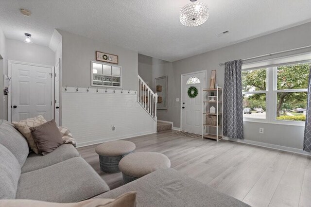 5208 Nightshadow Dr, Westerville, OH 43081 - living area featuring stairway, light wood finished floors, baseboards, and a textured ceiling