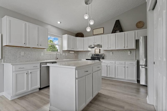 5208 Nightshadow Dr, Westerville, OH 43081 - kitchen featuring stainless steel appliances, under cabinet range hood, light wood-style floors, white cabinetry, and vaulted ceiling