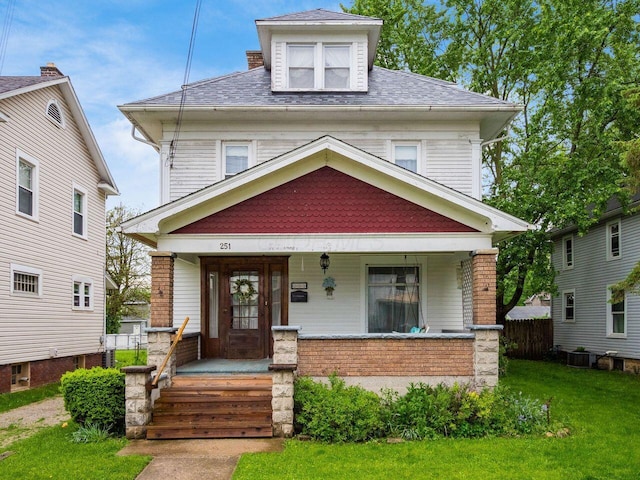251 Summit St, Marion, OH 43302 - american foursquare style home with covered porch, a front lawn, brick siding, and a shingled roof