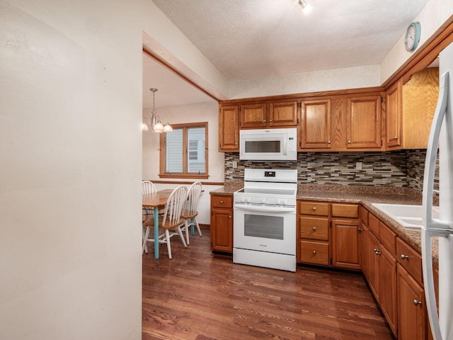 251 Summit St, Marion, OH 43302 - kitchen featuring white appliances, dark wood-type flooring, backsplash, brown cabinets, and a textured ceiling