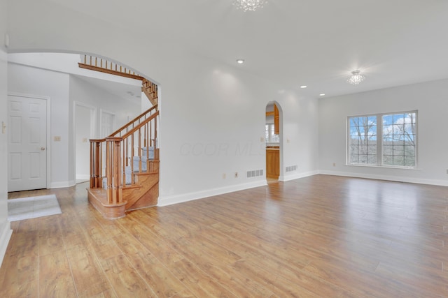 40455 Cone Rd, Albany, OH 45710 - unfurnished living room with arched walkways, light wood-style floors, stairway, and recessed lighting