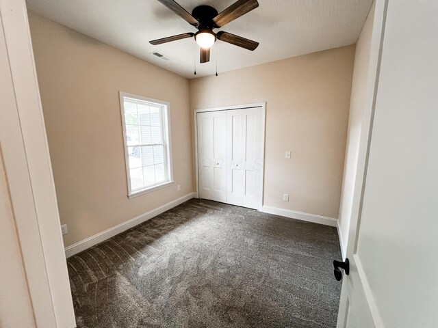 13541 Queen Rd NE, Thornville, OH 43076 - unfurnished bedroom with dark colored carpet, baseboards, a closet, and a ceiling fan