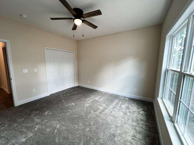 13541 Queen Rd NE, Thornville, OH 43076 - unfurnished bedroom with dark carpet, baseboards, a closet, and ceiling fan