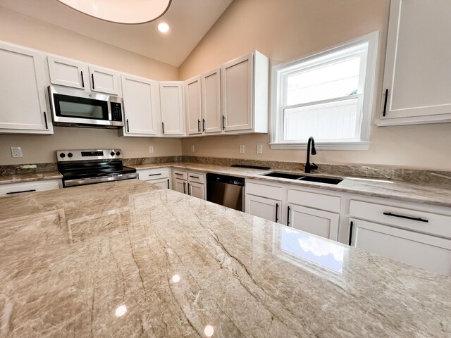 13541 Queen Rd NE, Thornville, OH 43076 - kitchen with stainless steel appliances, a sink, vaulted ceiling, white cabinets, and light stone countertops