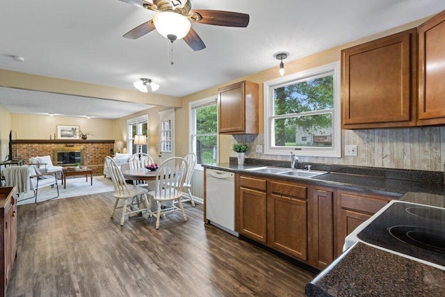 998 Timberbank Dr, Westerville, OH 43081 - kitchen featuring white dishwasher, a sink, dark countertops, a fireplace, and open floor plan