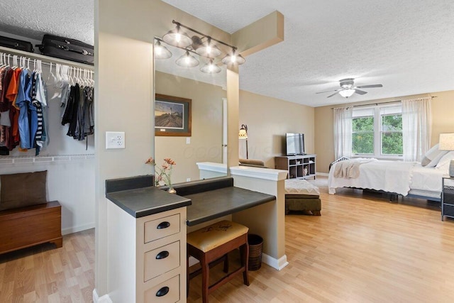 998 Timberbank Dr, Westerville, OH 43081 - bedroom featuring a textured ceiling, light wood-type flooring, a closet, baseboards, and a ceiling fan