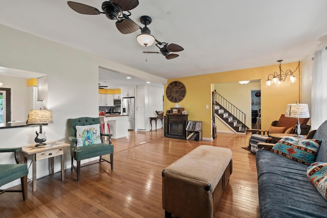 4736 Roberts Rd, Caledonia, OH 43314 - living room featuring a ceiling fan, stairs, light wood-style floors, a chandelier, and recessed lighting