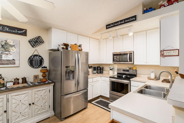 6621 Eagle Ridge Ln Unit 9C, Canal Winchester, OH 43110 - kitchen featuring appliances with stainless steel finishes, a sink, light wood-style flooring, white cabinetry, and lofted ceiling