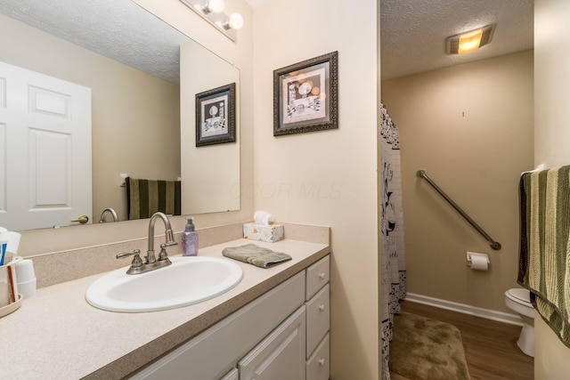 6621 Eagle Ridge Ln Unit 9C, Canal Winchester, OH 43110 - bathroom with vanity, wood finished floors, toilet, a textured ceiling, and baseboards
