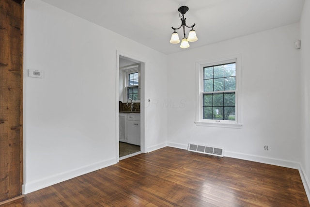 104 W Rathbone Ave, Columbus, OH 43214 - empty room with a chandelier, dark wood-style floors, baseboards, and a sink