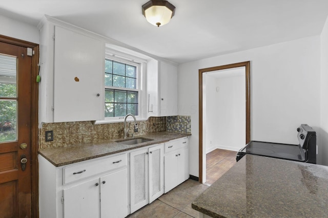 104 W Rathbone Ave, Columbus, OH 43214 - kitchen with a sink, range with electric stovetop, decorative backsplash, white cabinets, and light tile patterned floors
