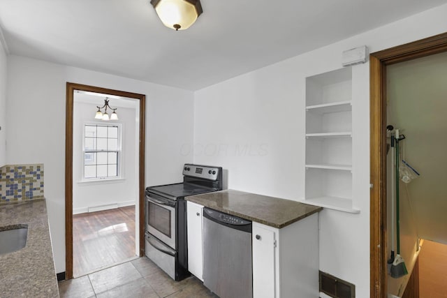 104 W Rathbone Ave, Columbus, OH 43214 - kitchen with appliances with stainless steel finishes, a chandelier, white cabinets, backsplash, and dark countertops