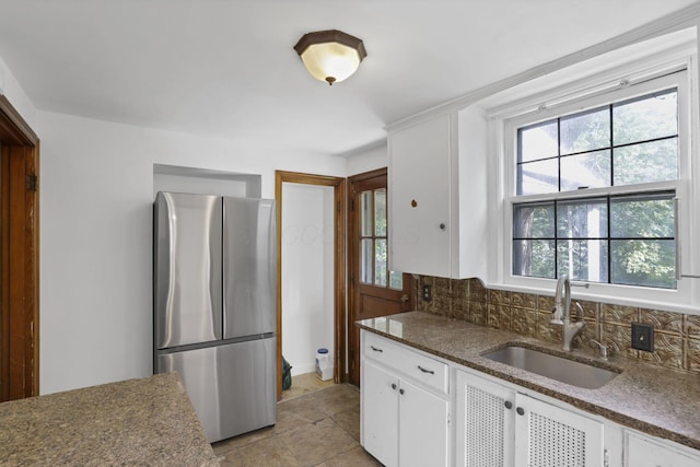 104 W Rathbone Ave, Columbus, OH 43214 - kitchen featuring freestanding refrigerator, a sink, decorative backsplash, and white cabinetry
