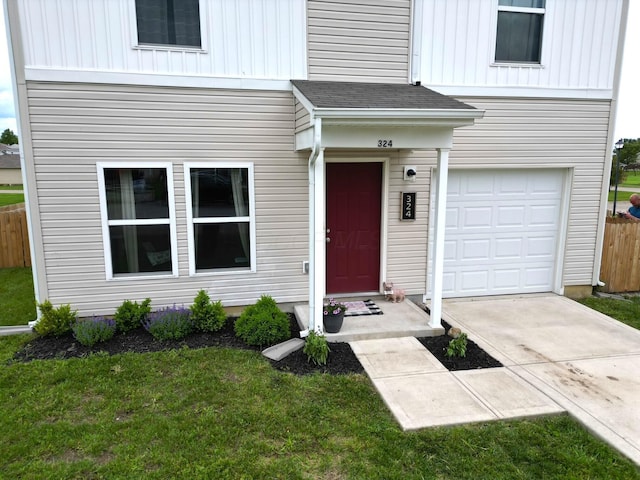 324 Genoa Rd, Commercial Point, OH 43116 - view of exterior entry with a garage, board and batten siding, and concrete driveway