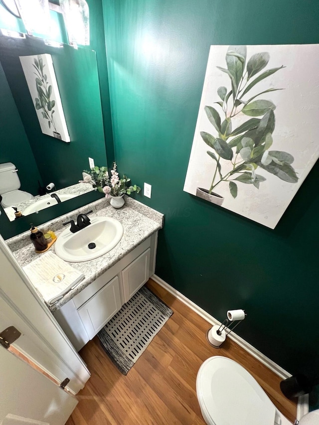 324 Genoa Rd, Commercial Point, OH 43116 - half bathroom featuring toilet, vanity, wood finished floors, and baseboards