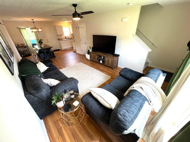 324 Genoa Rd, Commercial Point, OH 43116 - living room with wood finished floors, ceiling fan, a textured ceiling, baseboards, and a chandelier