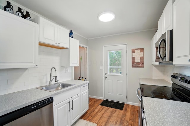 4367 San Jose Ln, Columbus, OH 43213 - kitchen featuring stainless steel appliances, a sink, light wood-style floors, ornamental molding, and decorative backsplash