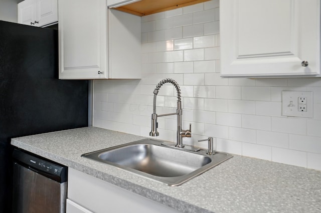 4367 San Jose Ln, Columbus, OH 43213 - kitchen with a sink, stainless steel dishwasher, backsplash, light countertops, and white cabinetry