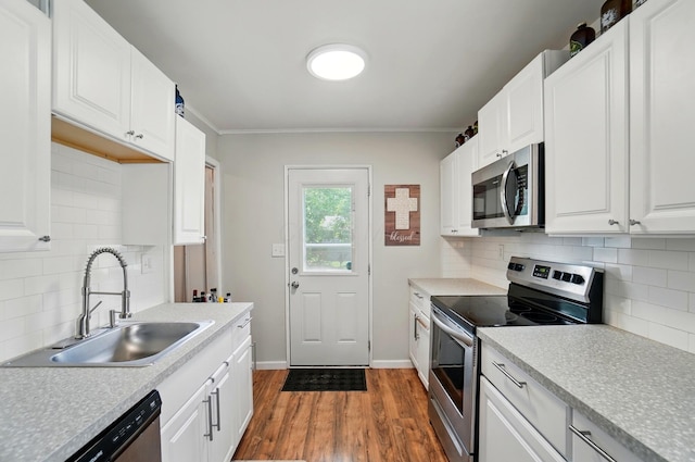 4367 San Jose Ln, Columbus, OH 43213 - kitchen featuring stainless steel appliances, a sink, dark wood finished floors, tasteful backsplash, and white cabinetry