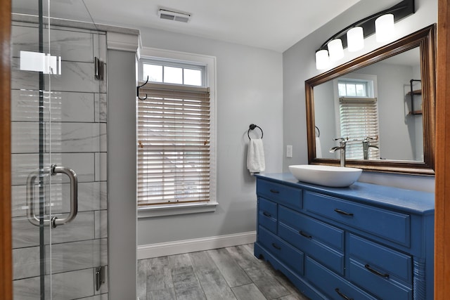 72 Glenmont Ave, Columbus, OH 43214 - bathroom featuring vanity, a stall shower, wood finished floors, and baseboards