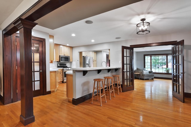 72 Glenmont Ave, Columbus, OH 43214 - kitchen with stainless steel appliances, french doors, a kitchen breakfast bar, light wood-type flooring, and recessed lighting