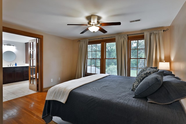 72 Glenmont Ave, Columbus, OH 43214 - bedroom featuring a sink, light wood-style floors, ensuite bathroom, baseboards, and ceiling fan