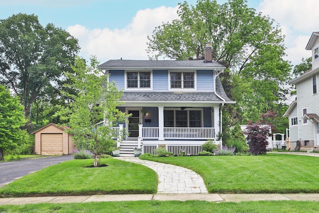 72 Glenmont Ave, Columbus, OH 43214 - view of front of home with covered porch, an outbuilding, a chimney, a front yard, and a garage