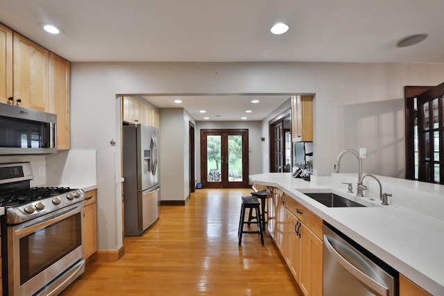 72 Glenmont Ave, Columbus, OH 43214 - kitchen with appliances with stainless steel finishes, a sink, light wood-style floors, recessed lighting, and french doors