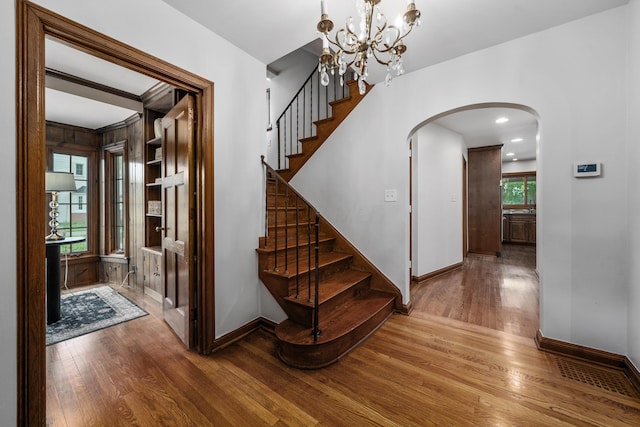 2656 Fair Ave, Columbus, OH 43209 - stairs featuring arched walkways, wood finished floors, baseboards, and a chandelier