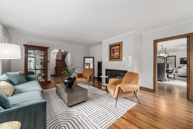 2656 Fair Ave, Columbus, OH 43209 - living room with a chandelier, wood finished floors, arched walkways, stairway, and crown molding