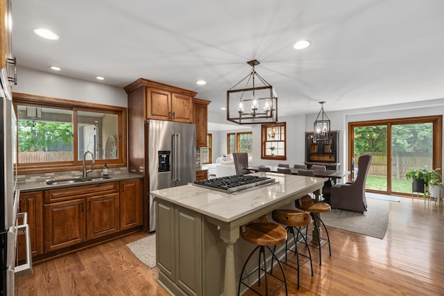 2656 Fair Ave, Columbus, OH 43209 - kitchen with a sink, appliances with stainless steel finishes, a chandelier, open floor plan, and wood finished floors