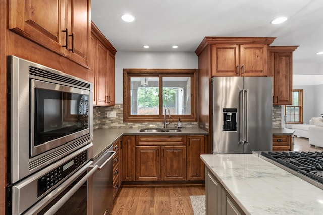 2656 Fair Ave, Columbus, OH 43209 - kitchen with appliances with stainless steel finishes, a sink, backsplash, recessed lighting, and brown cabinetry
