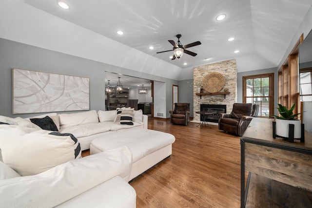 2656 Fair Ave, Columbus, OH 43209 - living area with lofted ceiling, wood finished floors, a stone fireplace, ceiling fan, and a chandelier