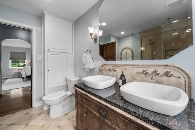 2656 Fair Ave, Columbus, OH 43209 - ensuite bathroom featuring double vanity, a tile shower, toilet, and recessed lighting