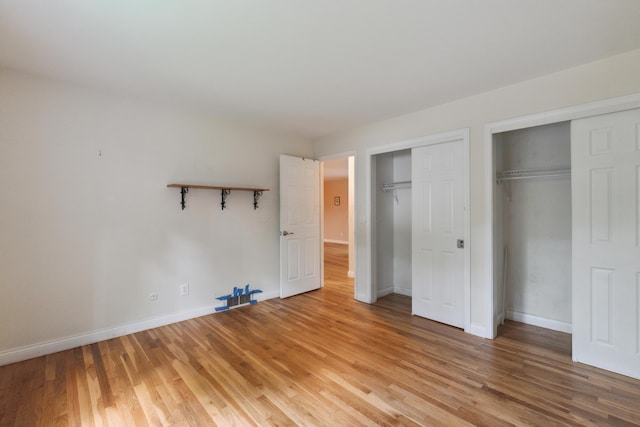 301 Fenway Rd Unit C, Columbus, OH 43214 - unfurnished bedroom featuring multiple closets, light wood-style floors, and baseboards