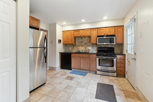 301 Fenway Rd Unit C, Columbus, OH 43214 - kitchen featuring stainless steel appliances, a sink, dark countertops, backsplash, and brown cabinets