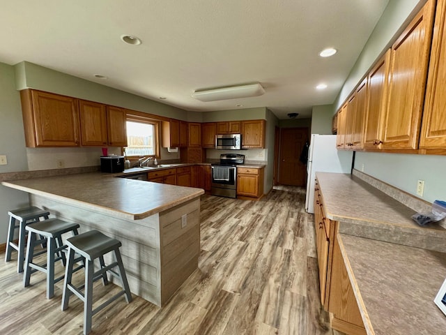 2580 Lafayette Plain City Rd, London, OH 43140 - kitchen featuring appliances with stainless steel finishes, light wood finished floors, a breakfast bar area, a peninsula, and recessed lighting