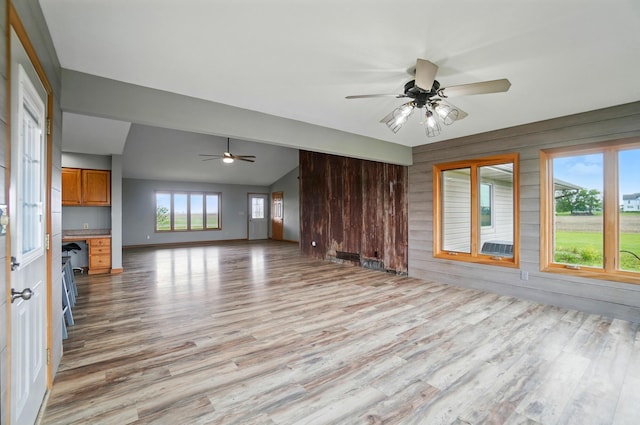 2580 Lafayette Plain City Rd, London, OH 43140 - unfurnished living room featuring ceiling fan, light wood finished floors, lofted ceiling, and wood walls