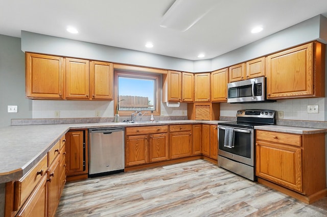2580 Lafayette Plain City Rd, London, OH 43140 - kitchen with stainless steel appliances, a sink, light wood-type flooring, tasteful backsplash, and light countertops