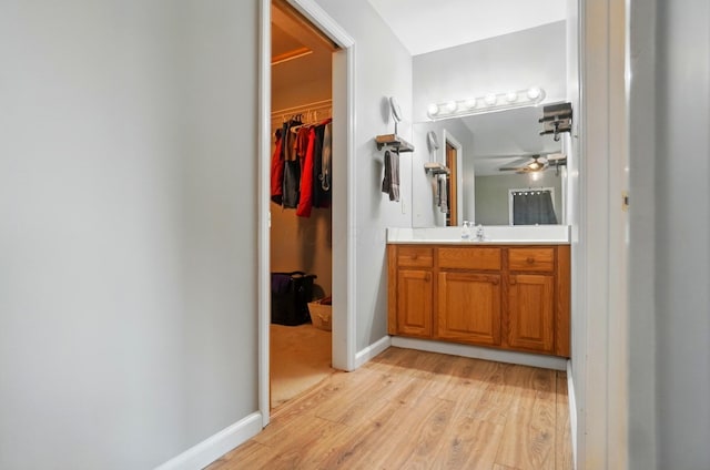 2580 Lafayette Plain City Rd, London, OH 43140 - bathroom featuring vanity, wood finished floors, a ceiling fan, a spacious closet, and baseboards
