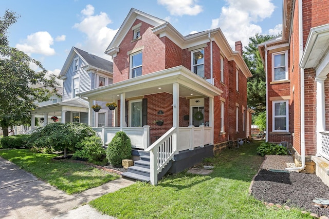 141 E 5th Ave, Lancaster, OH 43130 - view of front of property featuring brick siding, covered porch, and a front yard
