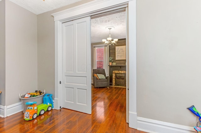 141 E 5th Ave, Lancaster, OH 43130 - corridor featuring a chandelier, wood finished floors, a textured ceiling, and baseboards